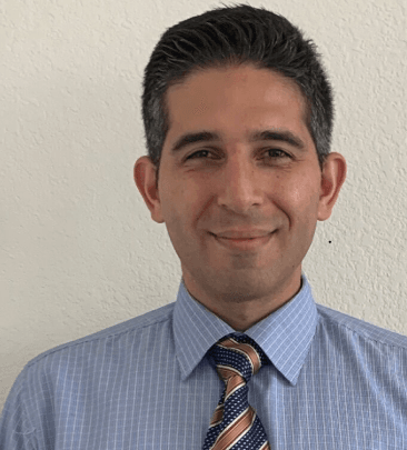 Smiling man in striped shirt and tie against white background