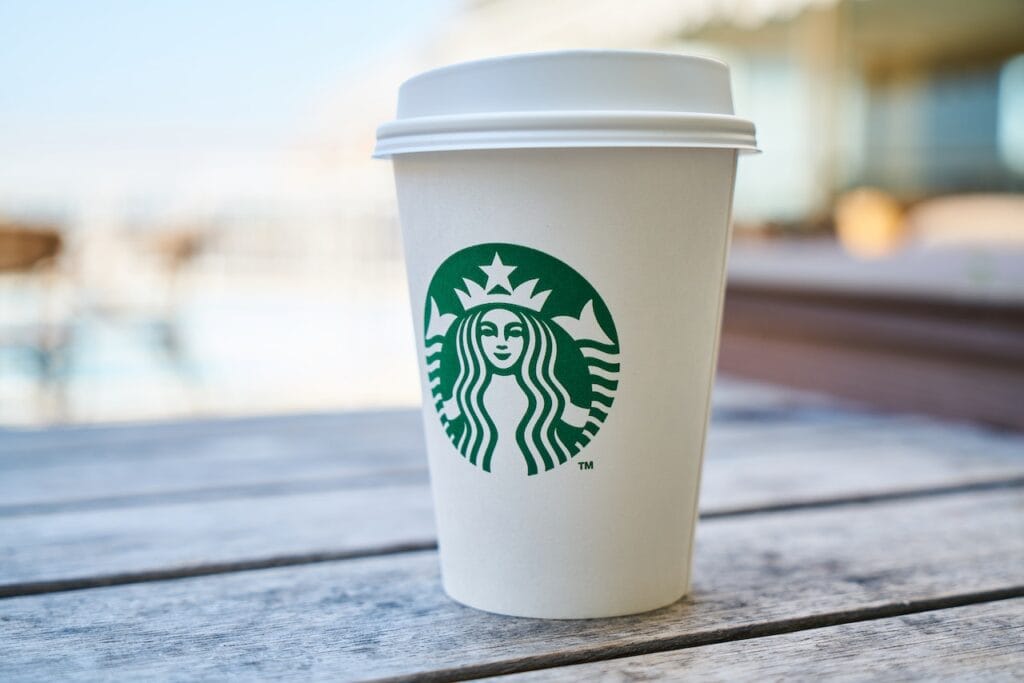 White Starbucks cup with green logo on wooden surface