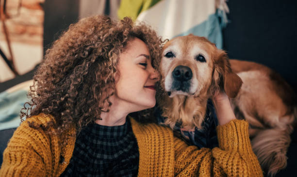 Woman bonding with golden retriever indoors